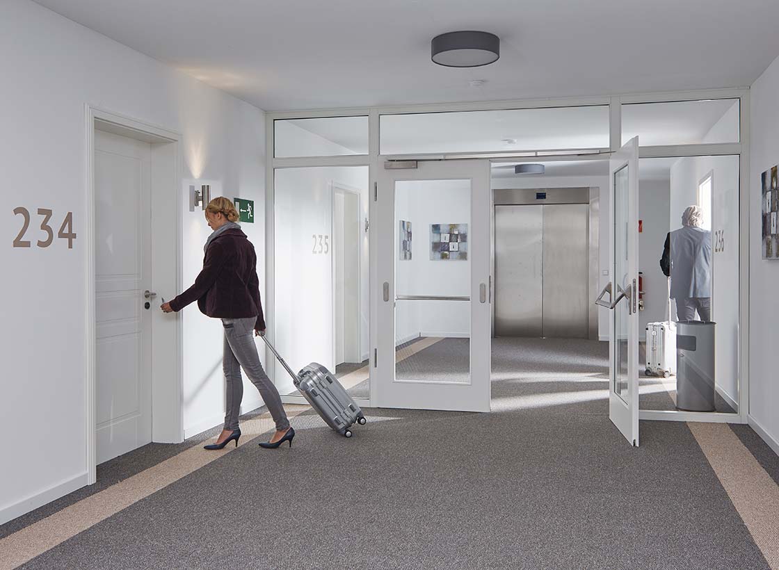 magazin_beitrag-wohnungseingangstueren_rauchschutz Magazinbeitrag Wohnungseingangstüren - Apartmentkomplex mit Türen in Weißlack Exklusiv 9010 und Glasanlage Weißlack Exklusiv 9010 mit Klarglas